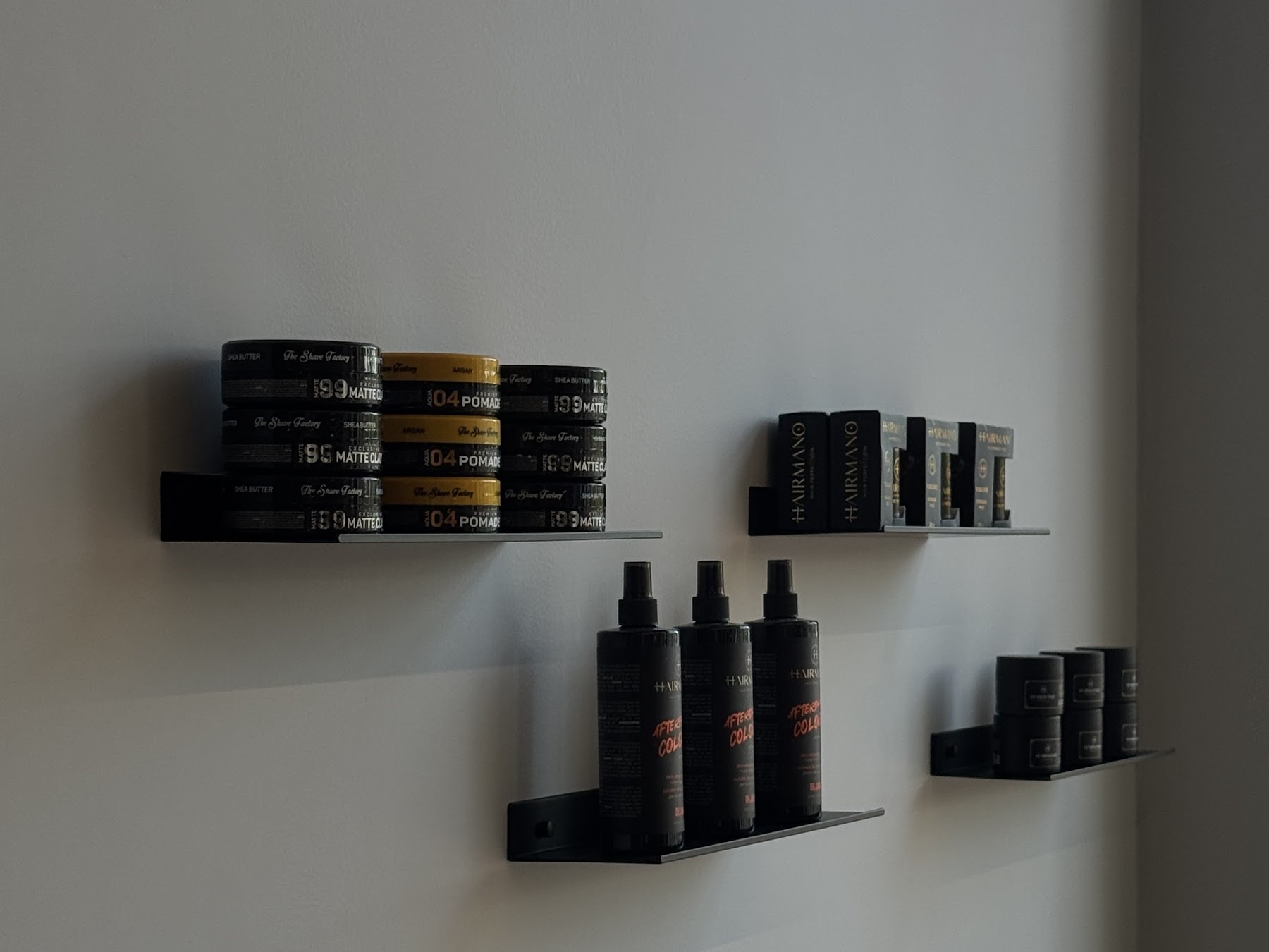Zwarte wandplankjes met pomades en sprays in de zaak